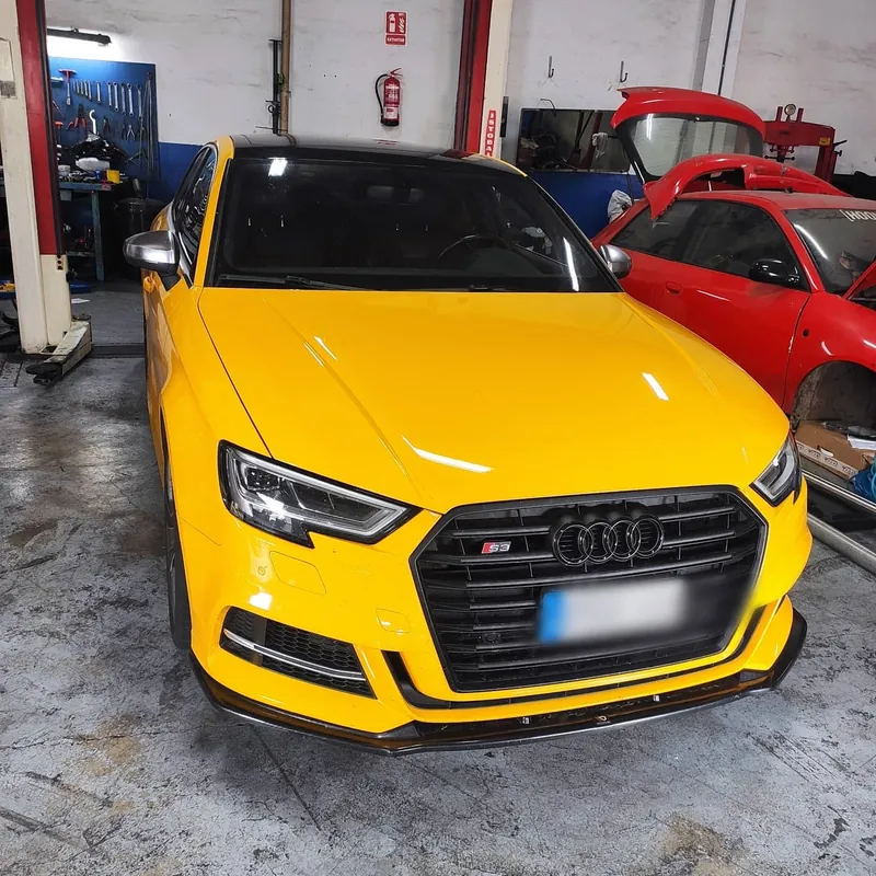 Audi S3 amarillo con splitter de carbono en el taller Ecomotor
